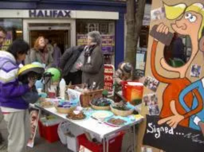 Fairtrade stall in Epsom High St with cartoon board for photos