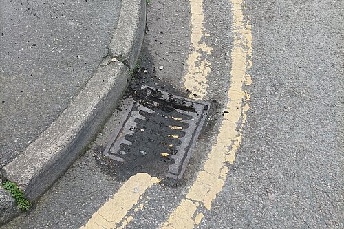 Blocked street drain and double yellow lines