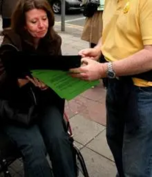 Wheelchair user signing petition